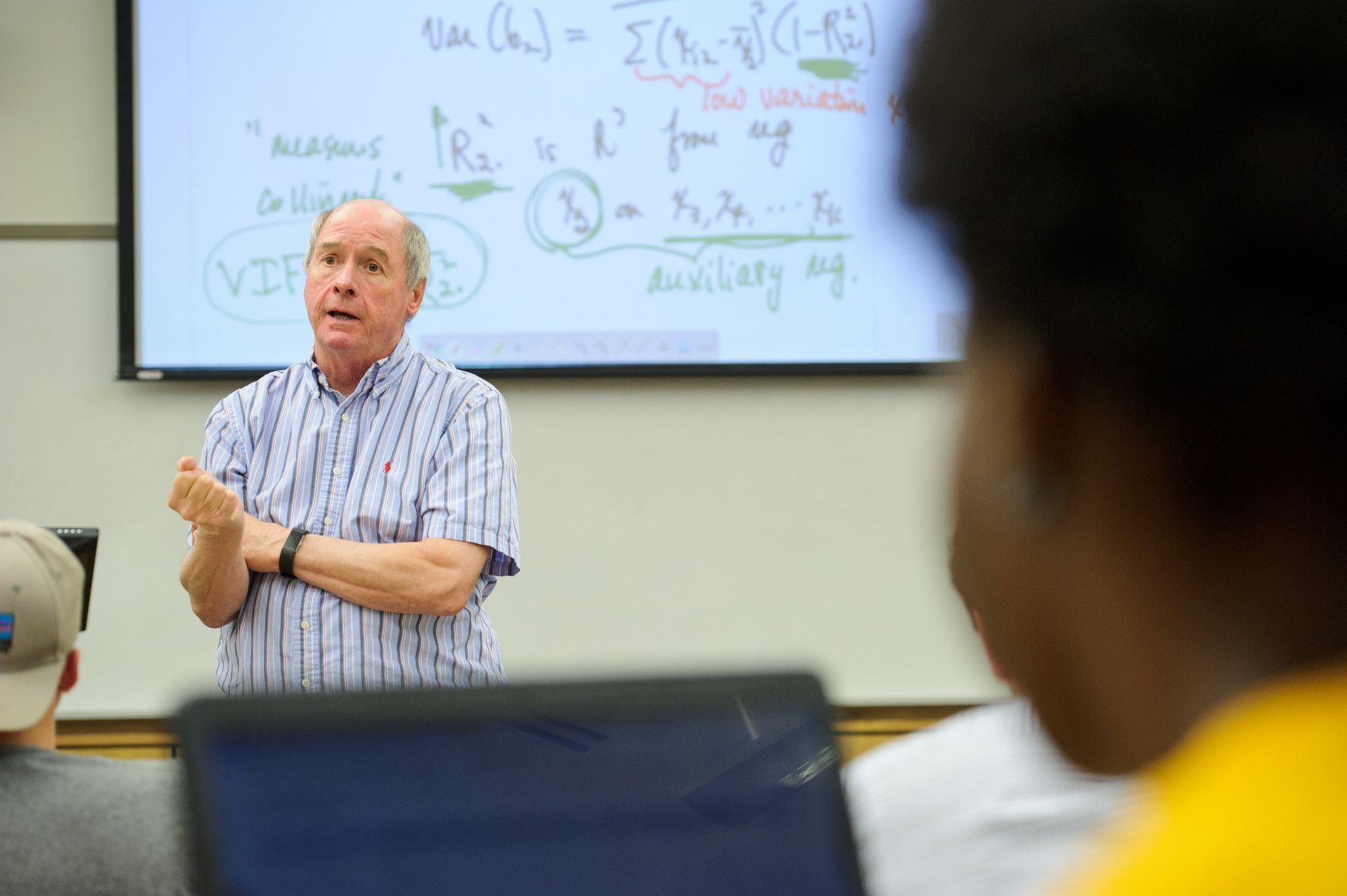 Professor teaching in front projector screen.