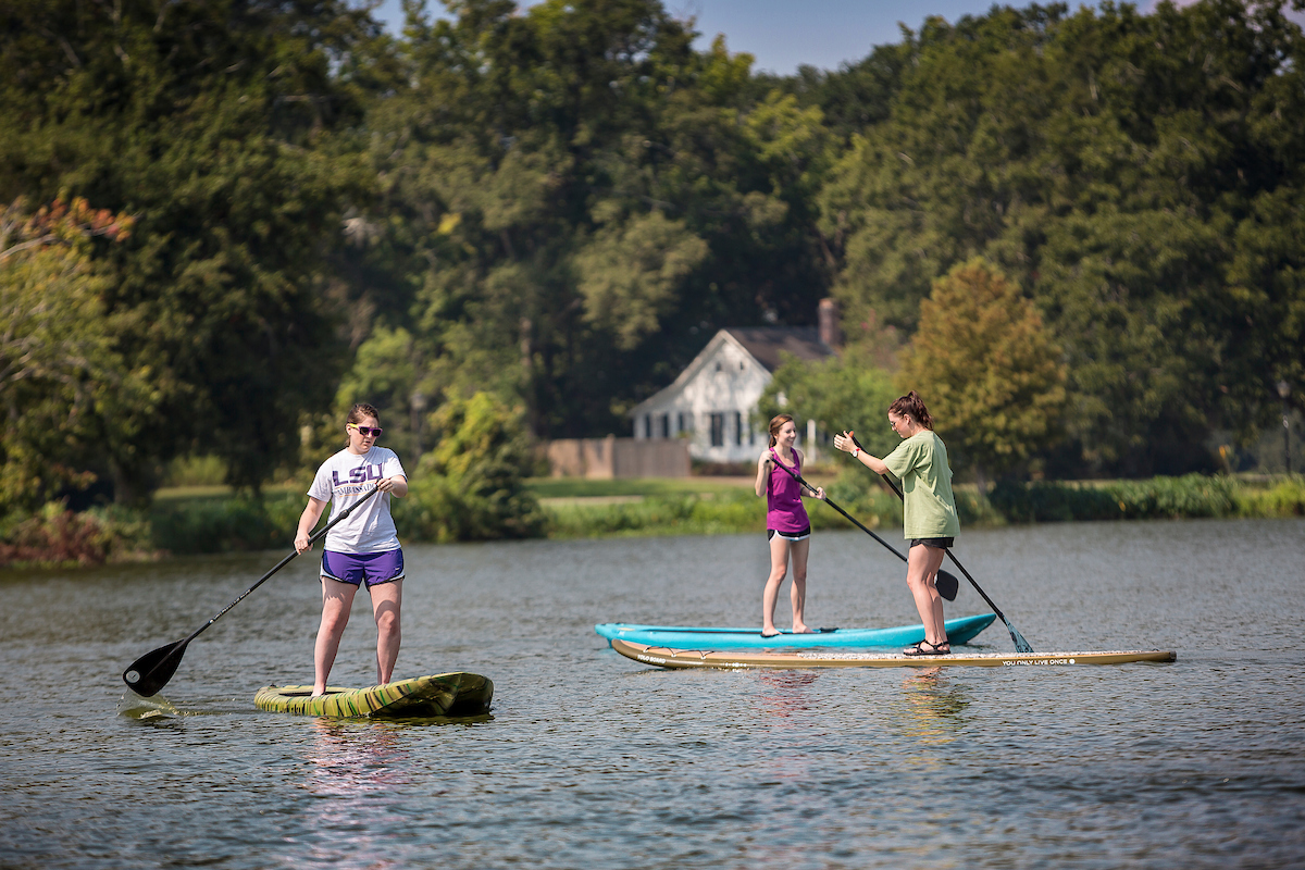 students paddleboarding on LSU Lakes